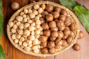 Roasted Macadamia nut in wooden plate on wooden background.
