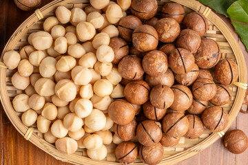 Roasted Macadamia nut in wooden plate on wooden background.