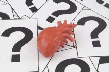 Heart FAQ concept. Human heart model on question marks.