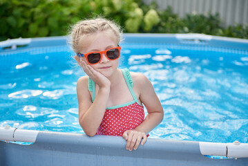 Little girl is bored alone in the pool