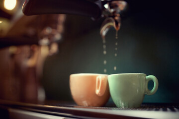 making coffee. detail of pouring drops. close up of two cups. orange and green