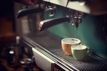selective focus of espresso device, pouring jet of coffee into two cups