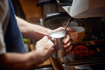 Fototapeta na wymiar Caucasian man making milk foam for a coffee