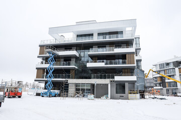 Luxurious apartments for sale. Bricks and concrete. Construction site background in winter. New...