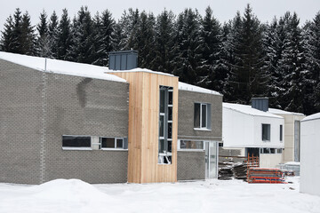 Suburban modern American house under construction in the winter snow
