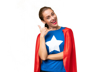 Young caucasian woman over isolated background in superhero costume and doing phone gesture