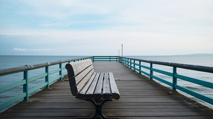 Fototapeta na wymiar An empty bench sitting on a pier with a calm ocean in the background Generative AI