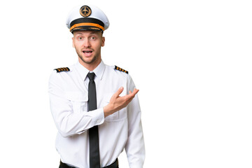Airplane pilot man over isolated background surprised and pointing side