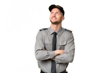 Young security caucasian man over isolated background looking up while smiling