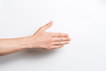 Close-up of a man's hand. He stretches out his hand for a handshake gesture on a white background.