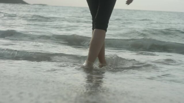 Close-up of Feet, Pretty Blonde Girl Walking Barefoot into the waves at the Beach, Bleik, Lofoten Islands, Norway, Beautiful Sunset Atmosphere
