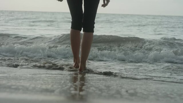 Pretty Blonde Girl Walking Barefoot into the waves at the Beach, Bleik, Lofoten Islands, Norway, Beautiful Sunset Atmosphere