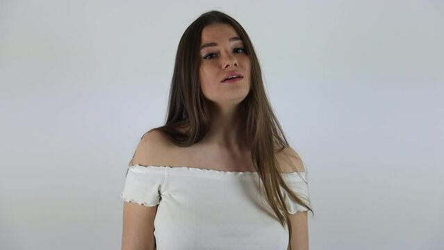 Slow motion clip of an attractive young lady singing in front of a white background