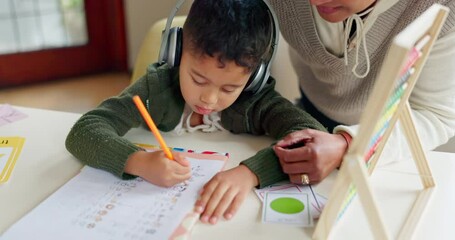 Education, writing and mother with son in a kitchen for distance learning, maths and headphones for autism. Special needs, tutor or remote learning for autistic kid with mom for help, support or care - Powered by Adobe