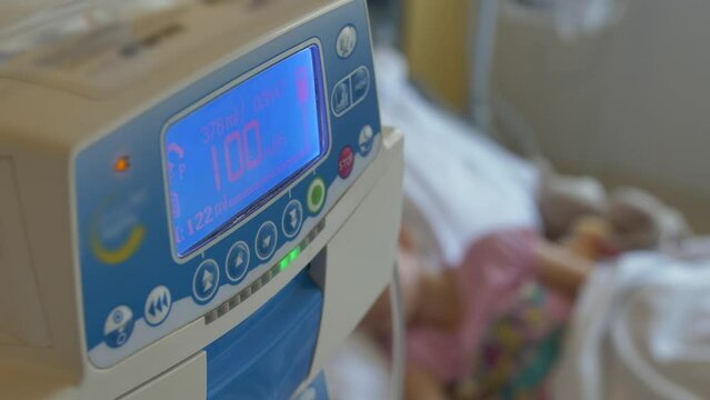Young Girl on a Drip with Peripheral Venous Catheter Reading Book in Hospital