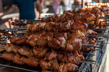 A lot of appetizing fried kebab on skewers on the counter. Popular tasty street food. Close-up.