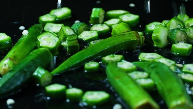 Drops of water falling on okra, or lady's fingers on a wet surface. slow motion