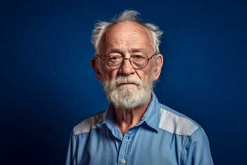 Medium shot portrait photography of a tender old man wearing a casual short-sleeve shirt against a royal blue background. With generative AI technology