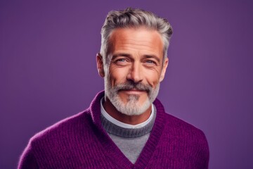 Obraz premium Close-up portrait photography of a glad mature man wearing a cozy sweater against a vibrant purple background. With generative AI technology