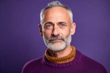 Obraz premium Close-up portrait photography of a glad mature man wearing a cozy sweater against a vibrant purple background. With generative AI technology