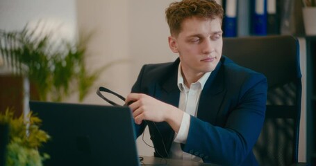 Contemplative manager with laptop at workplace.