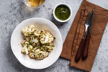 Roasted white cauliflower in bowl on rustic grey table