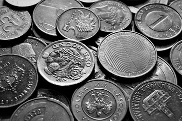 A fragment of a coin pile. Coins of different countries, black and white image. Background. - obrazy, fototapety, plakaty