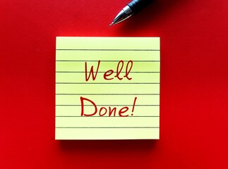 Note on red background with handwritten text WELL DONE, compliment or praise giving to someone to...