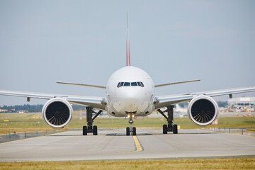 Airplane is taxiing to runway for take off during sunny summer day. Hot air behind jet engines of...
