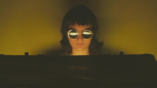Girl in round sunglasses opening black trunk with mysterious gold glowing hidden treasure. Cinematic 80s 90s style scene. Thriller, fantasy adventure movie concept. Thief, smuggler, burglar character 
