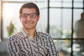Obraz premium Charming handsome. Handsome young man in casual wear keeping arms crossed while standing