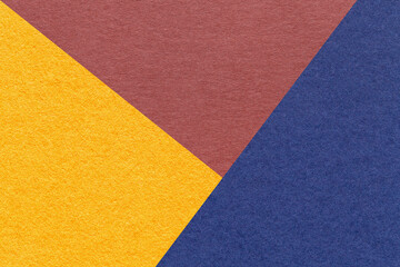 Fototapeta premium Texture of craft yellow, red and navy blue shade color paper background, macro. Structure of vintage abstract cardboard
