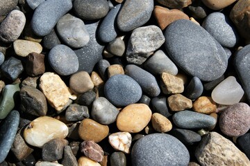 Fototapeta na wymiar Stones of different sizes on the beach. Background texture.