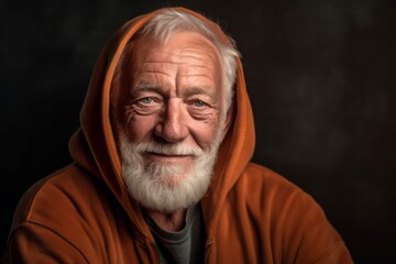 Obraz premium Close-up portrait photography of a satisfied old man wearing a stylish hoodie against a rustic brown background. With generative AI technology