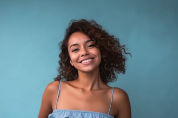 Medium shot portrait photography of a satisfied girl in her 30s wearing a daring tube top against a soft blue background. With generative AI technology