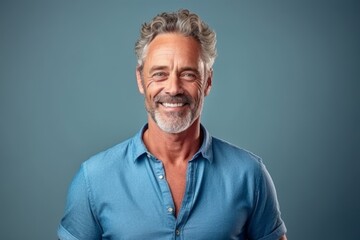 Obraz premium Medium shot portrait photography of a tender mature man wearing a casual short-sleeve shirt against a soft blue background. With generative AI technology