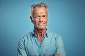 Obraz premium Medium shot portrait photography of a tender mature man wearing a casual short-sleeve shirt against a soft blue background. With generative AI technology