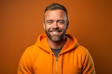 Fototapeta premium Headshot portrait photography of a satisfied boy in his 30s wearing a cozy zip-up hoodie against a tangerine orange background. With generative AI technology