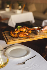 Appetizing chicken legs with barbecue sauce and hot peppers on a wooden board. Knife Fork. Food photography.