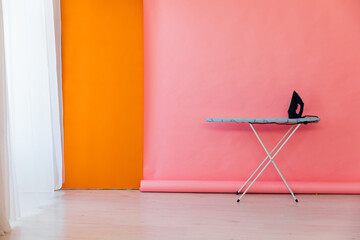 Interior Ironing Board Iron on Pink Orange Background