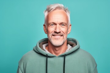 Headshot portrait photography of a satisfied mature man wearing a stylish hoodie against a pastel green background. With generative AI technology