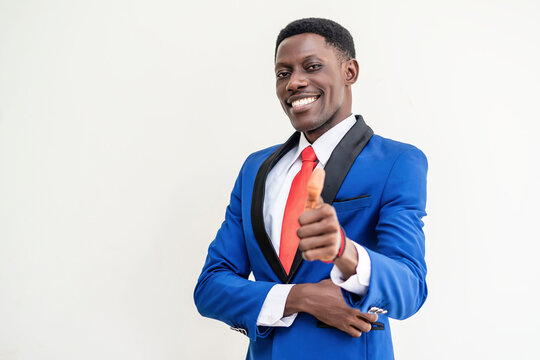 A man in a blue suit giving thumbs up