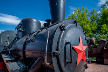 An old black steam locomotive with a red star.