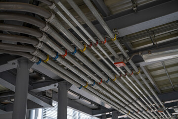 Electrical conduit system and tube of electric cable installed on building ceiling. Industrial...