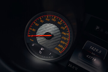 Modern car close up view of tachometer and speedometer carbon dashboard with backlight