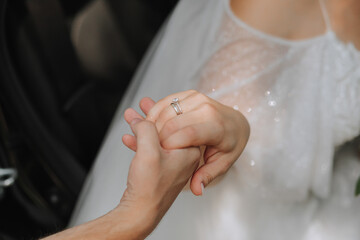 the bride and groom are tenderly holding hands close-up