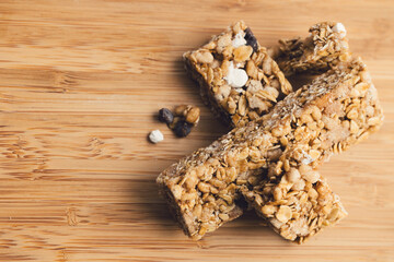 close up of healthy snack granola bar with chocolate chips on bamboo cutting board