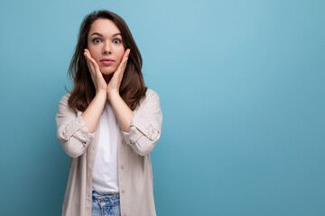 pretty european brunette young woman in a stylish look on a blue background with copy space