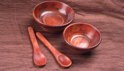 Empty wooden bowl and wooden spoon isolated with copy space.