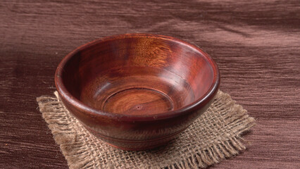 Empty wooden bowl and wooden spoon isolated with copy space.